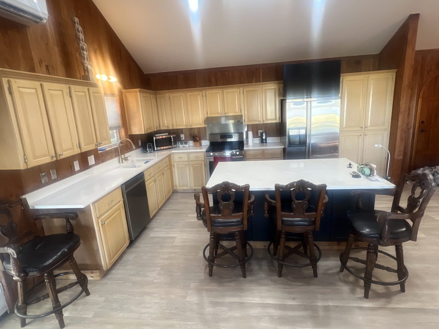 Same kitchen finished with new flooring, white countertops and a large island