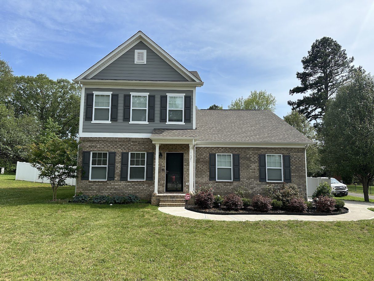 Two-story brick and siding home with its original weathered shingle roof