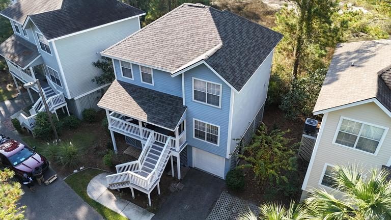 Aerial view of a completed architectural shingle roof replacement on a three-story Lowcountry home